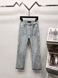 Light blue denim jeans with embellished side panels and cuffed hem