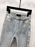 Light blue denim jeans with button fly, front pockets, and jeweled side trim