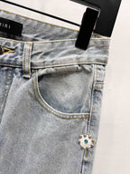 Light blue denim jeans with button waist and jeweled charm trim near pocket