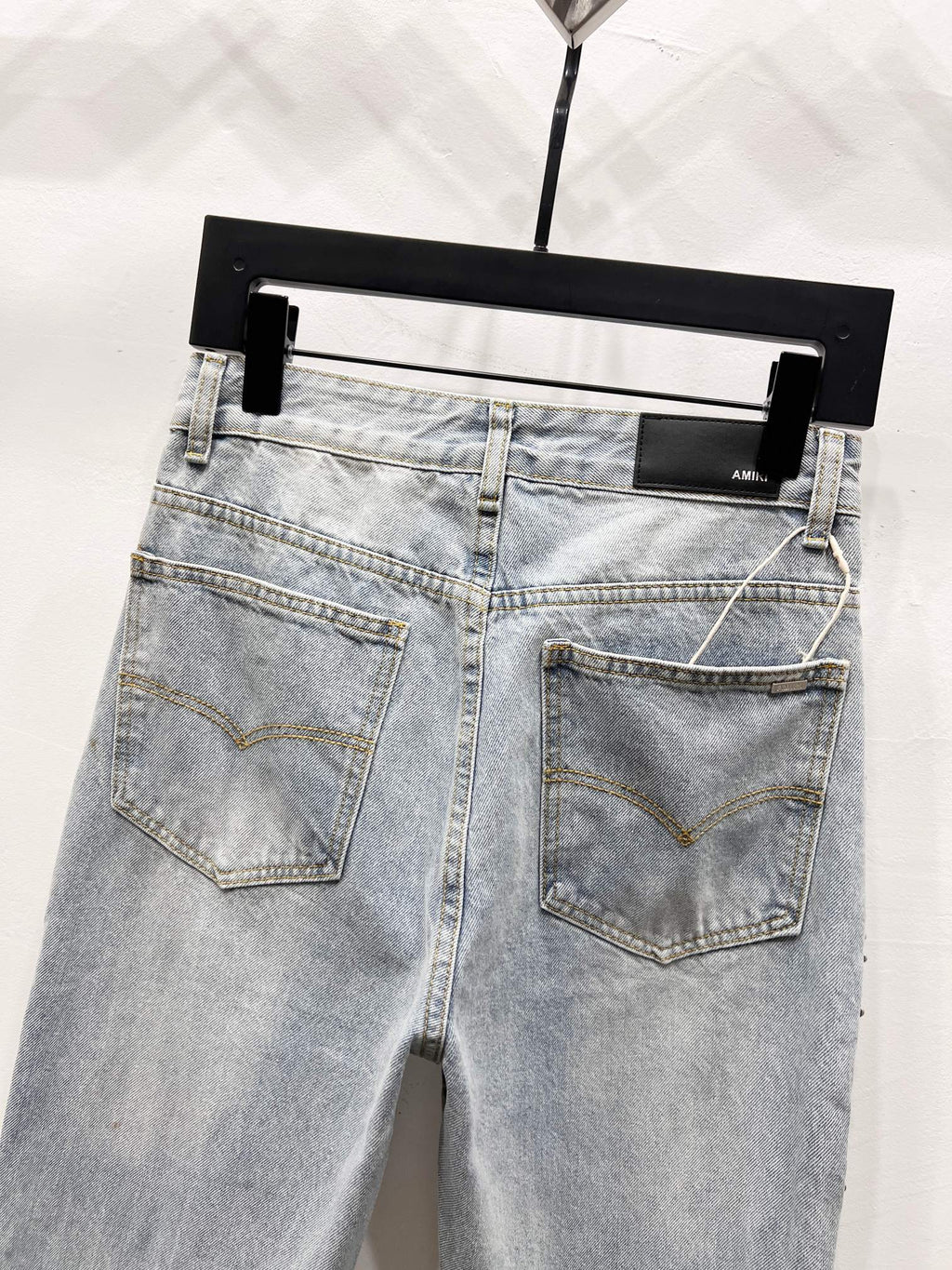 Light blue denim jeans with back patch pockets and jeweled side trim
