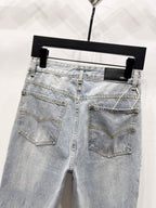 Light blue denim jeans with back patch pockets and jeweled side trim