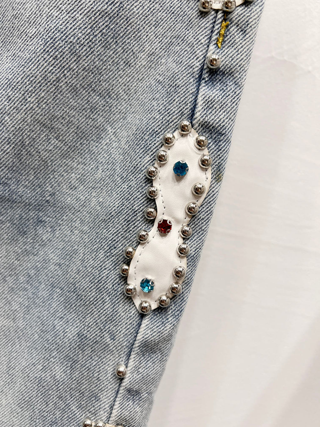 Light blue denim jeans with colorful beaded charm trim along side seam