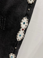Black denim with silver-tone studs and colorful crystal accents along a side seam