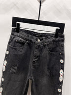 Black denim jeans with AMIRI waistband label and side studded floral trim