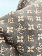 Brown knit fabric with repeating monogram motifs