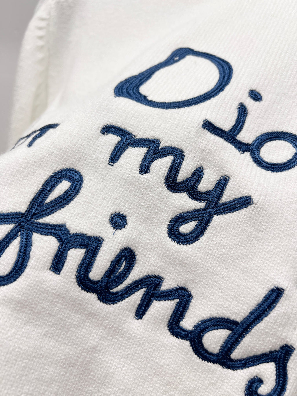 White sweatshirt with blue cursive embroidered lettering