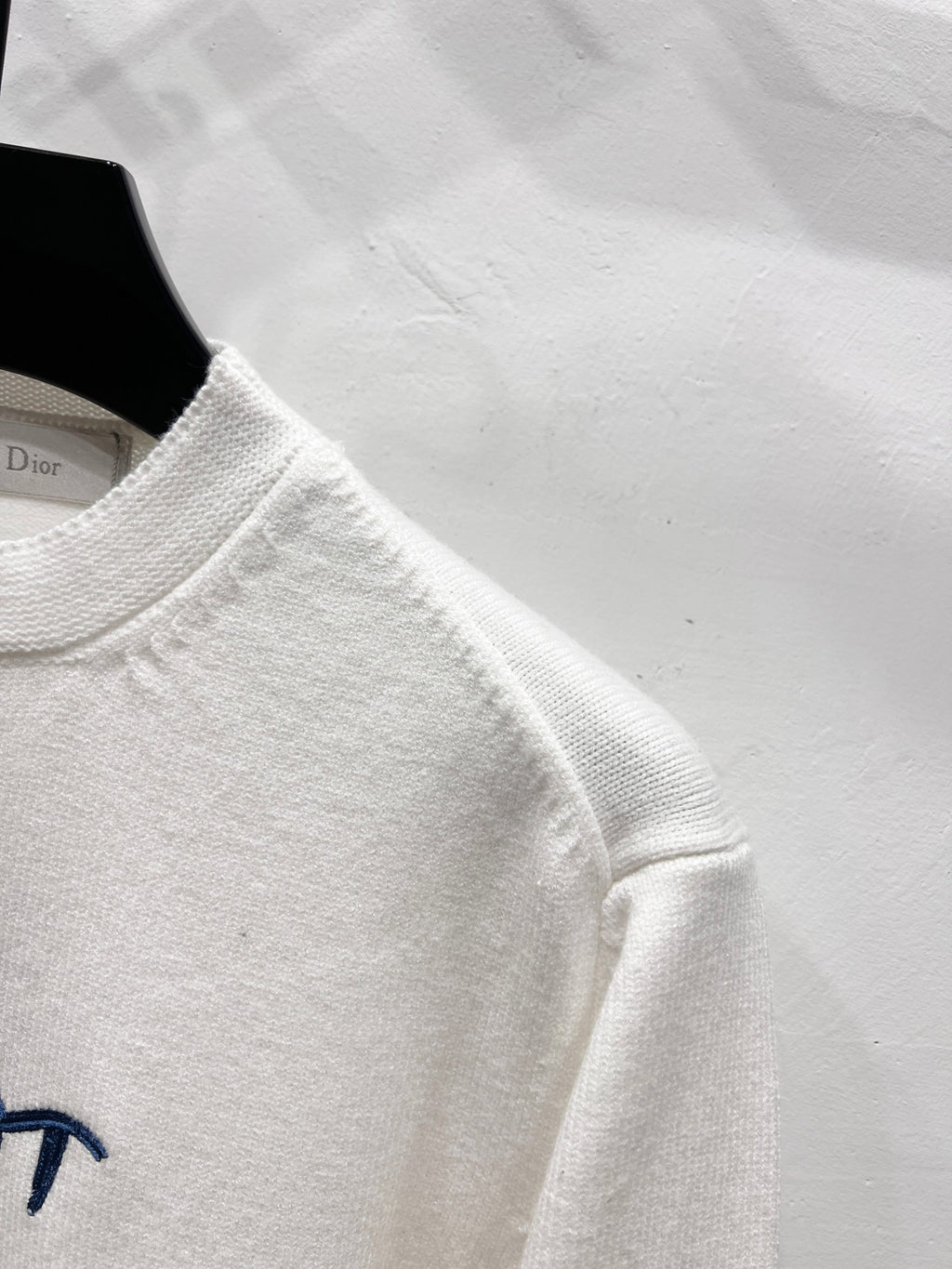 White long-sleeve sweatshirt sleeve and crew neckline detail