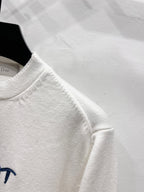 White long-sleeve sweatshirt sleeve and crew neckline detail