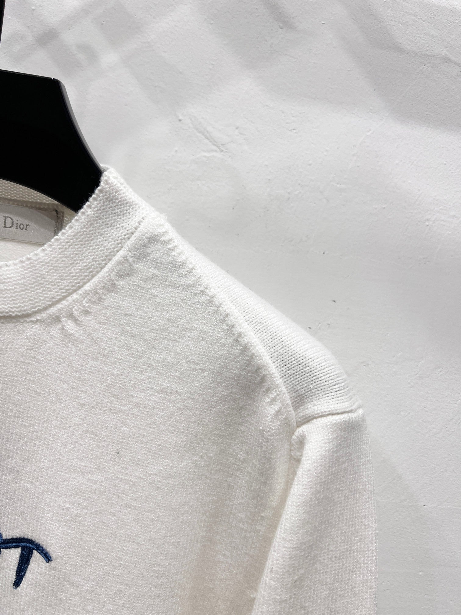 White long-sleeve sweatshirt sleeve and crew neckline detail