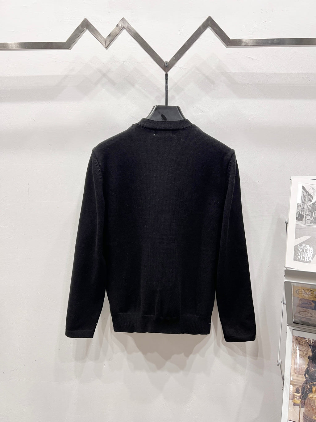 Black long-sleeve sweatshirt back view on hanger