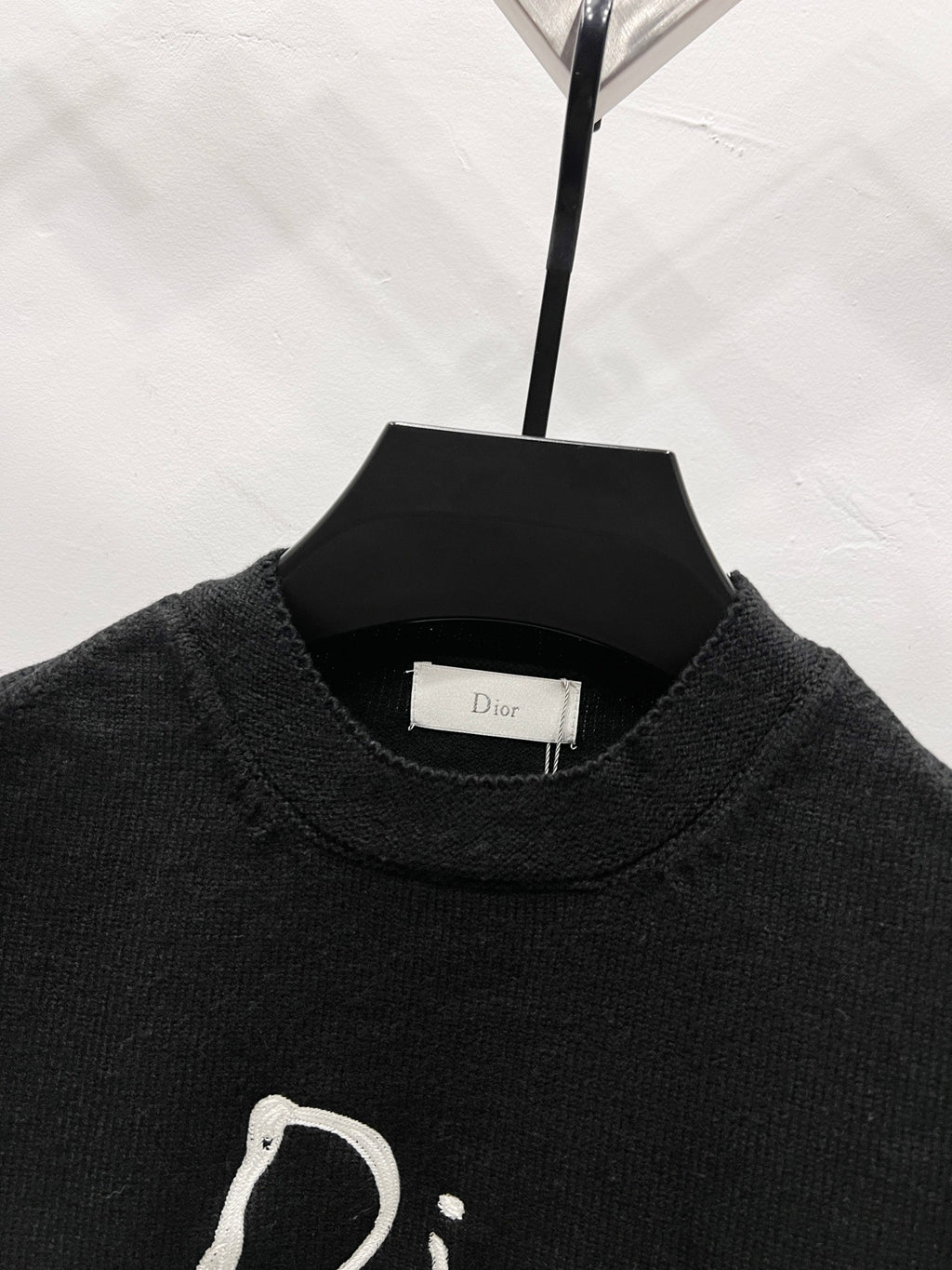 Black long-sleeve sweatshirt collar and partial white Dior script