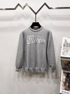 Gray long-sleeve knit sweatshirt with ribbed crew neck and white Gucci logo print