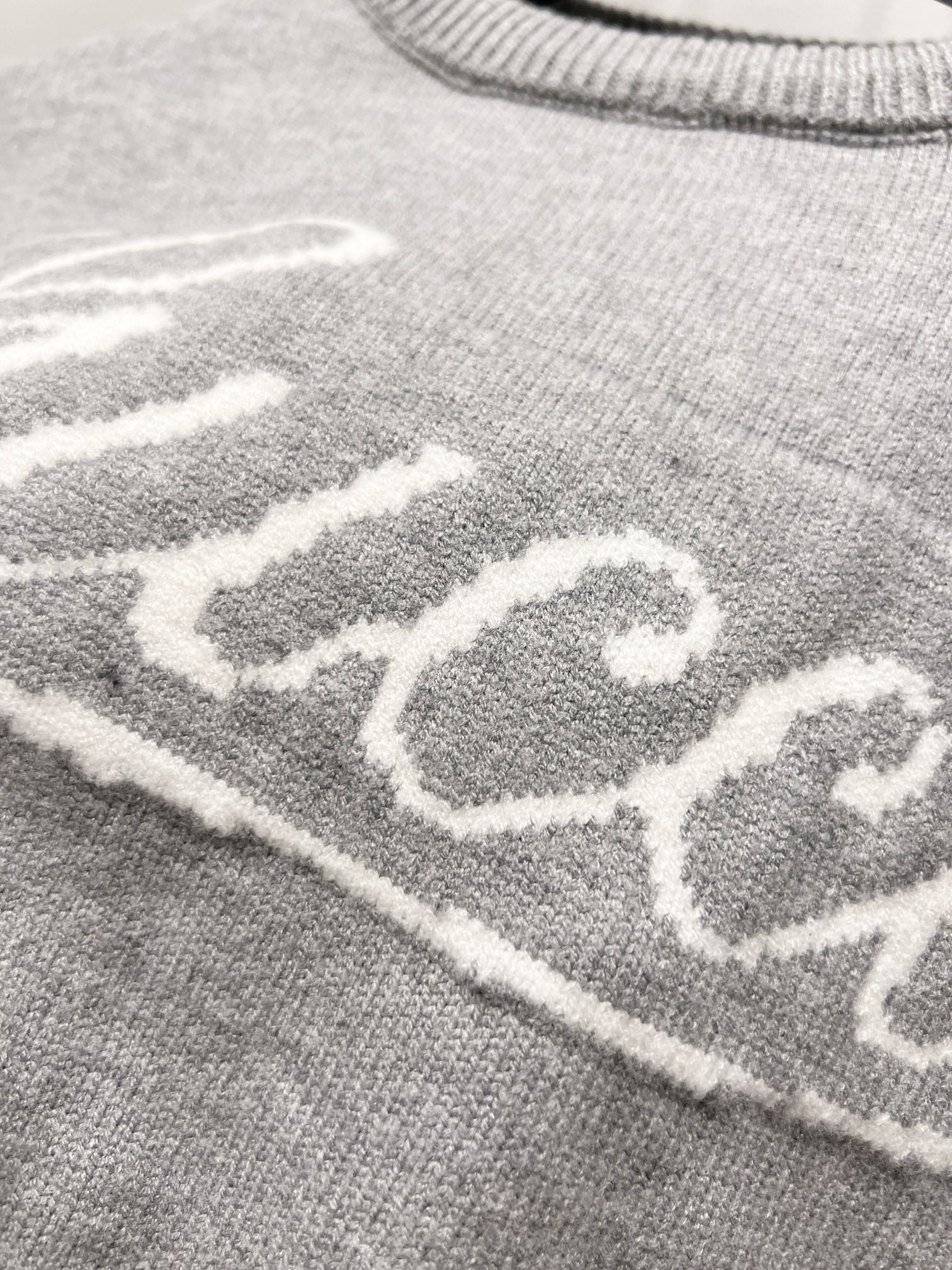 Gray knit fabric with white Gucci lettering detail