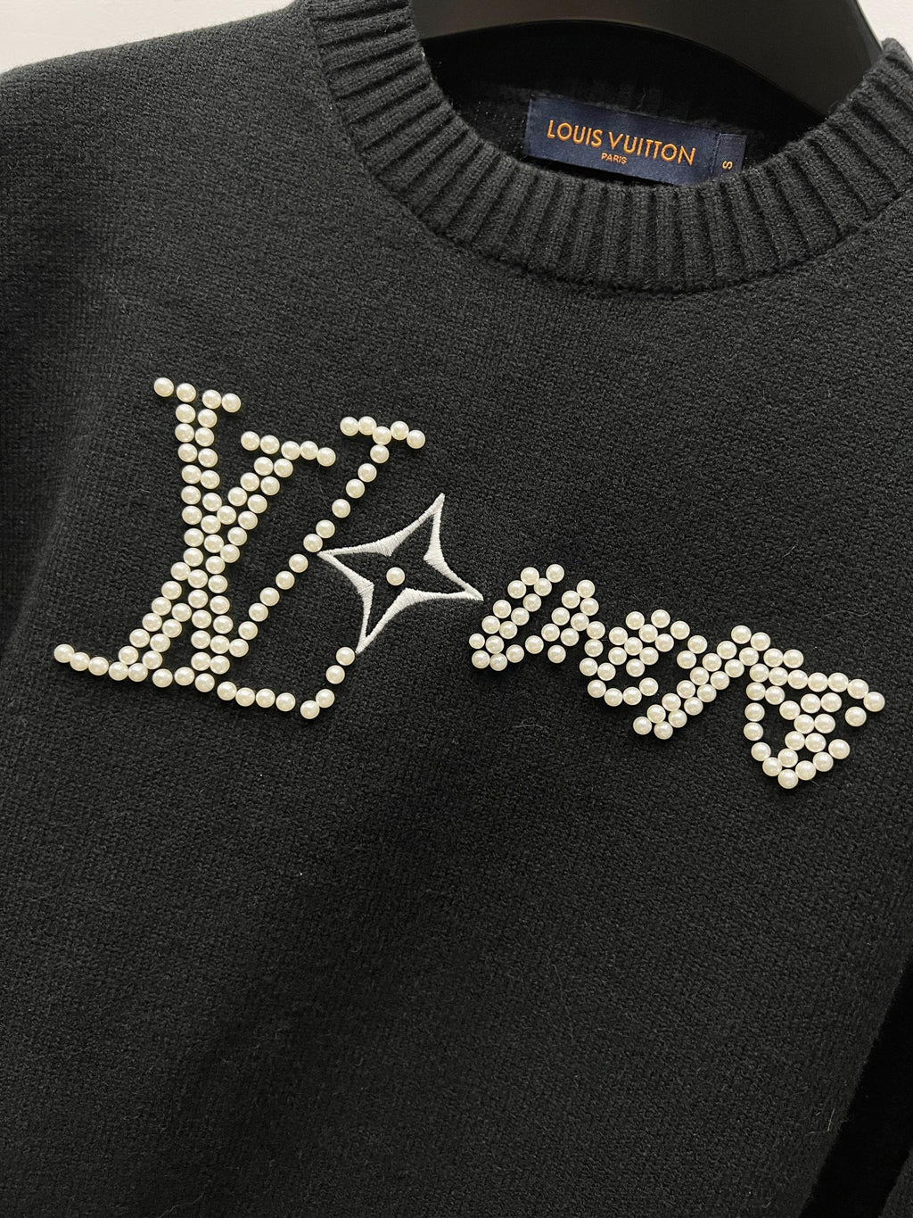 Louis Vuitton black sweater front with large rhinestone LV logo