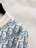 Knitted sleeve cuff and shoulder, light blue logo pattern on off-white ribbed trim