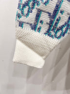 Sweater hem and sleeve cuff, off-white knit with light blue repeating logo pattern
