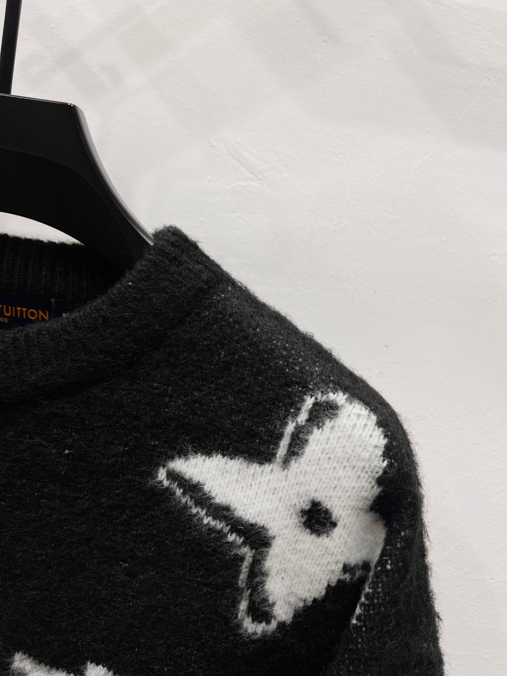 Black knit sweater sleeve with white star and LV-style monogram detail