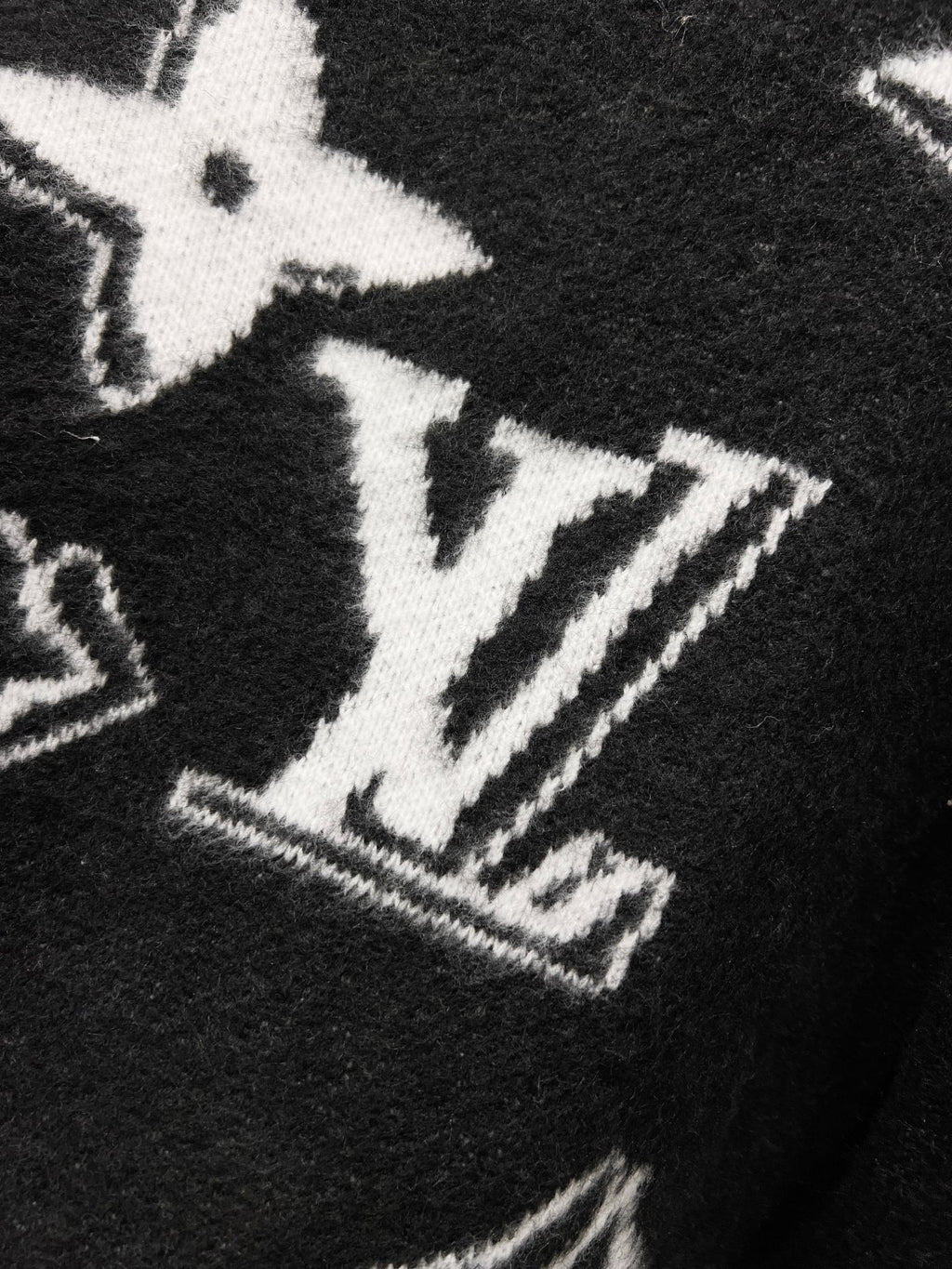 Black knit sweater with large white LV-style monogram graphic