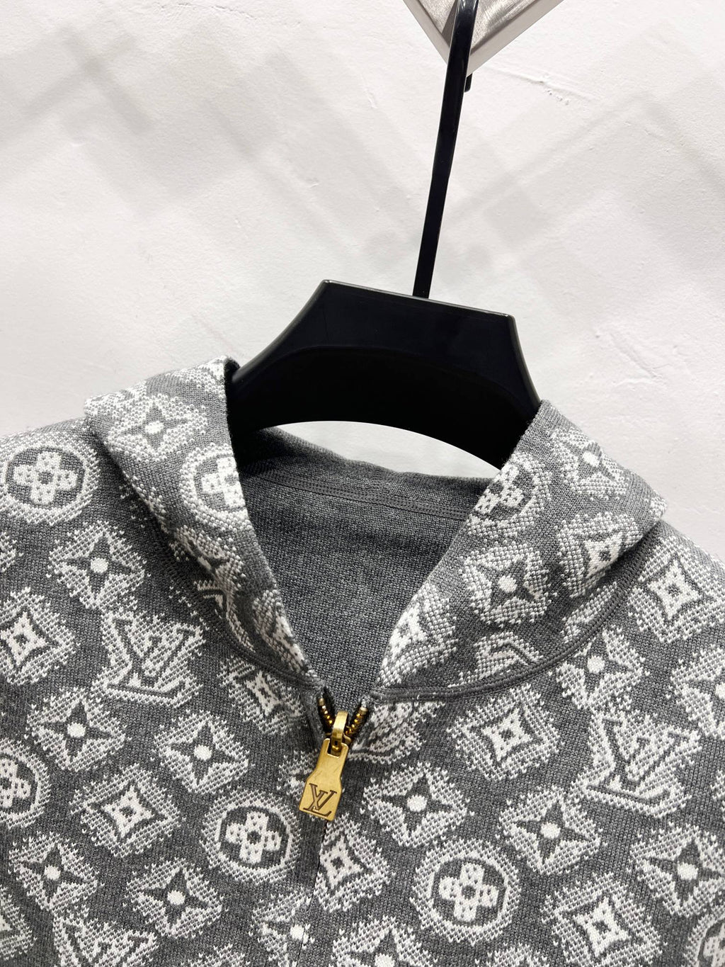 Patterned zip hoodie neckline detail in dark gray with gold zipper pull