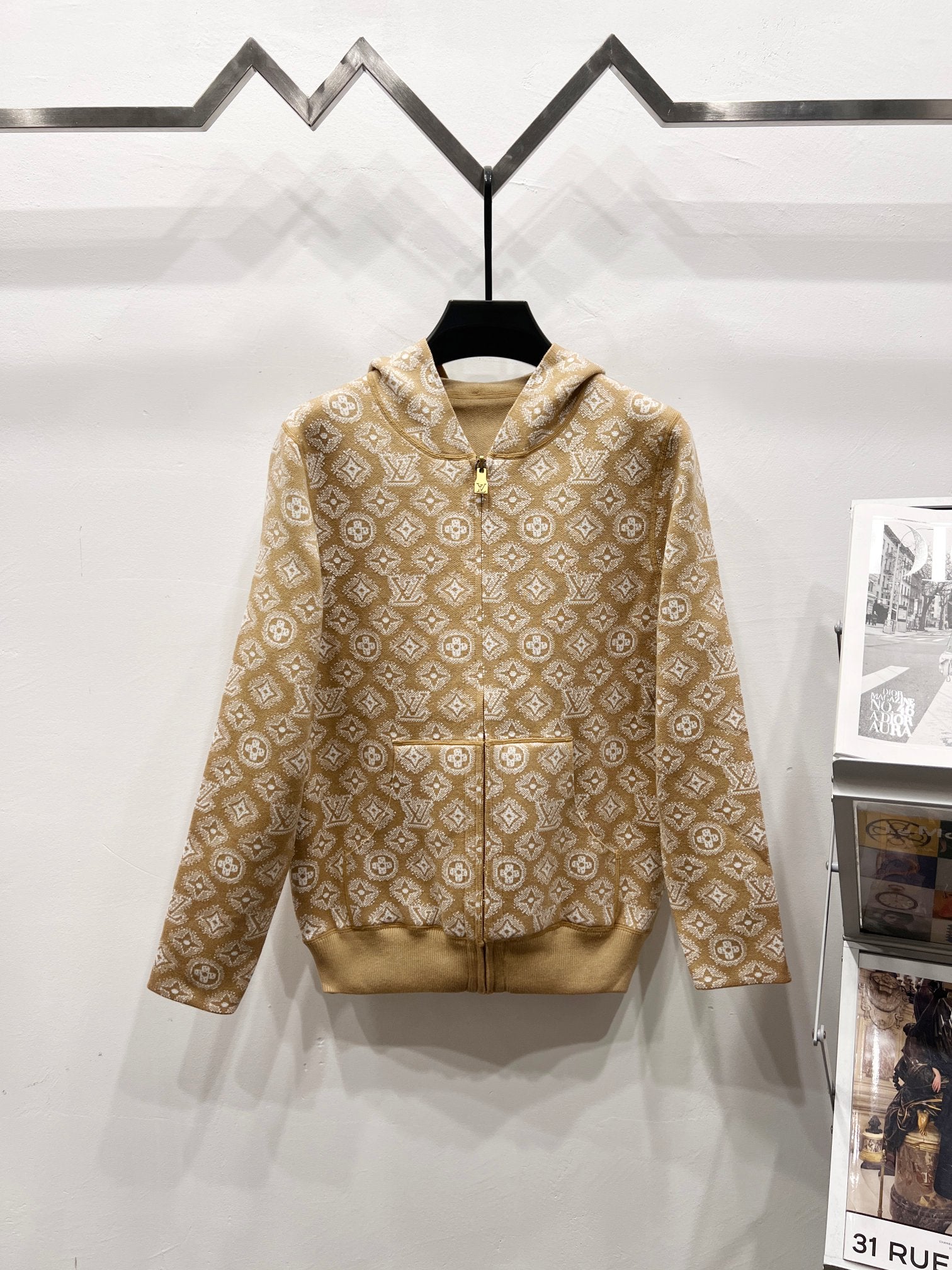 Tan zip-up hoodie with allover monogram pattern and beige hood lining