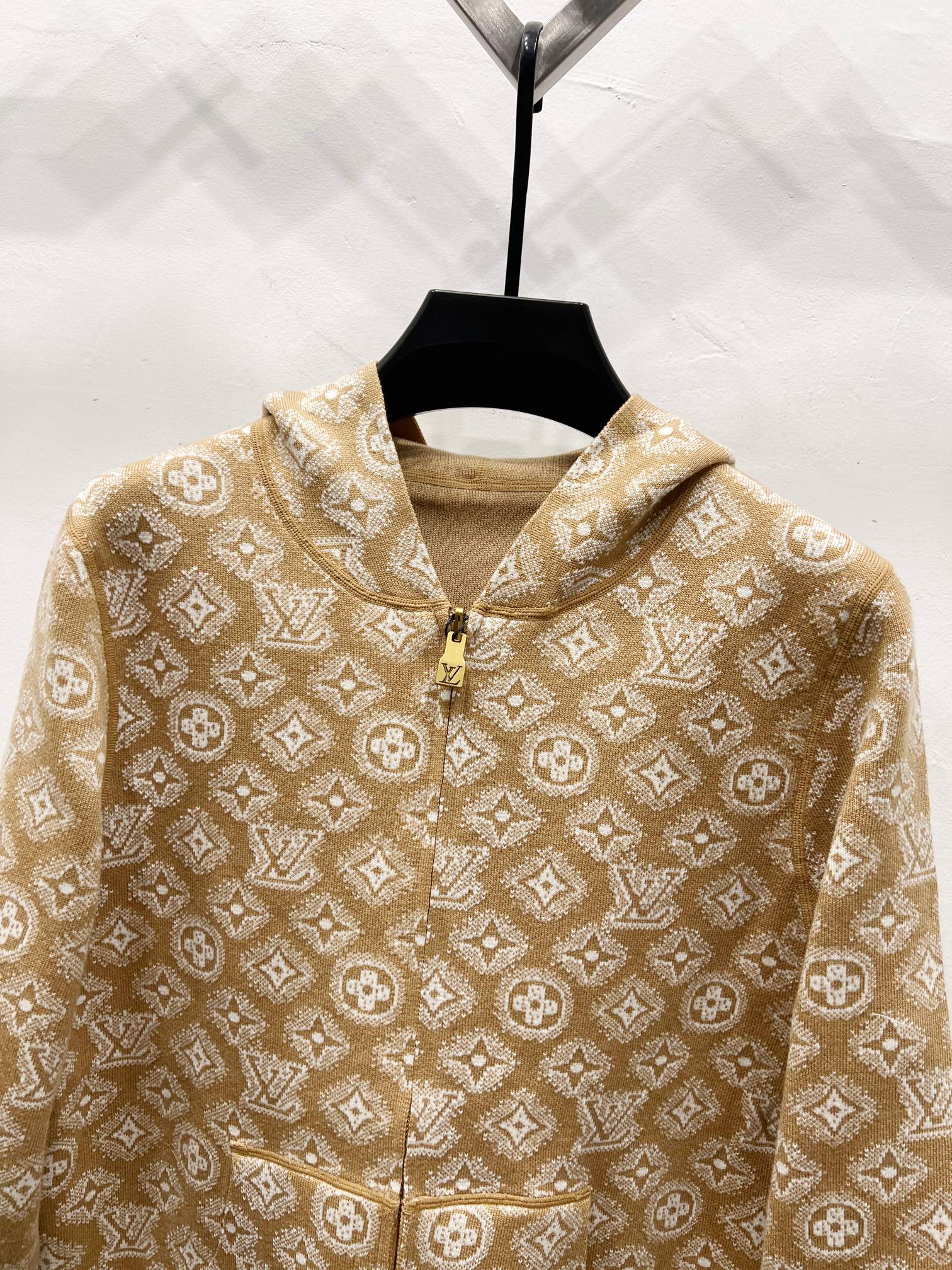 Tan monogram zip-up hoodie close-up with gold zipper and hood drawstring