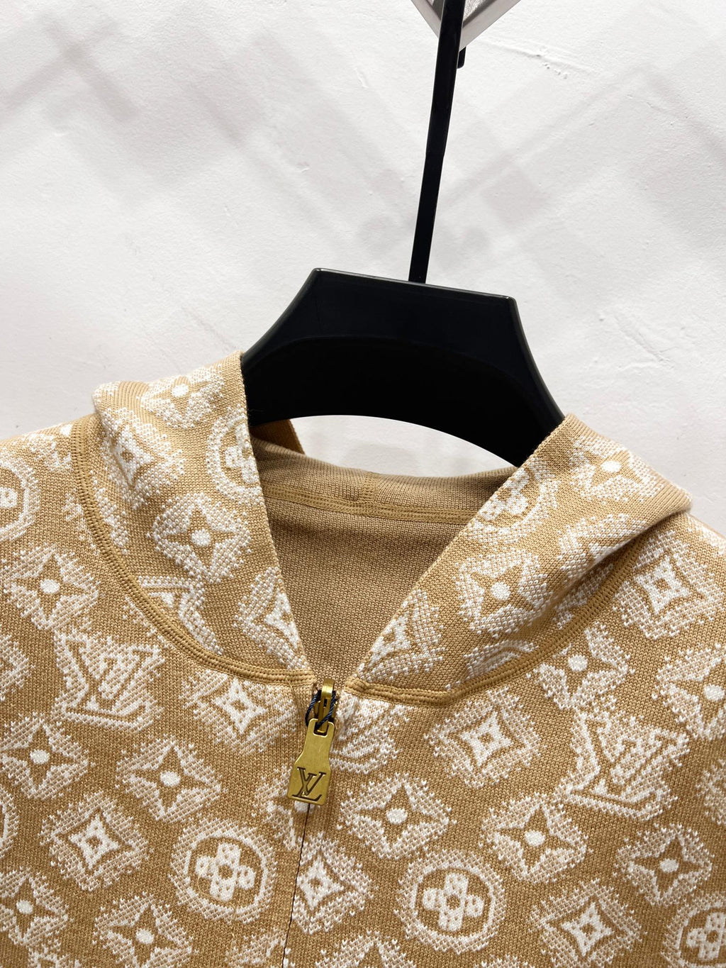 Tan monogram zip-up hoodie collar close-up with gold zipper and knit trim