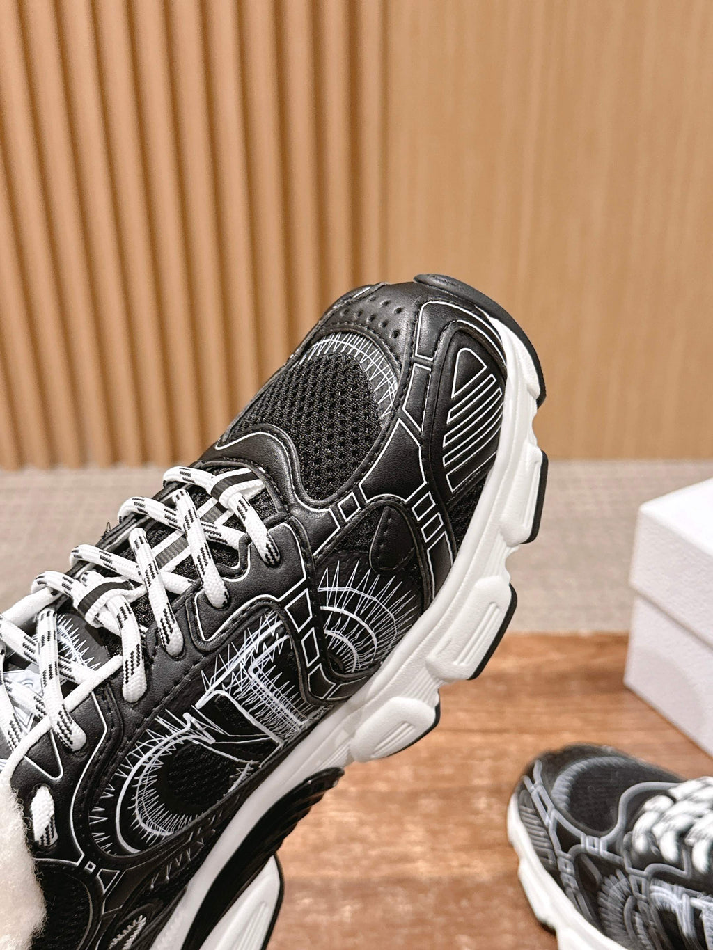 Side view unisex sneakers in black with white graphic details and chunky white sole