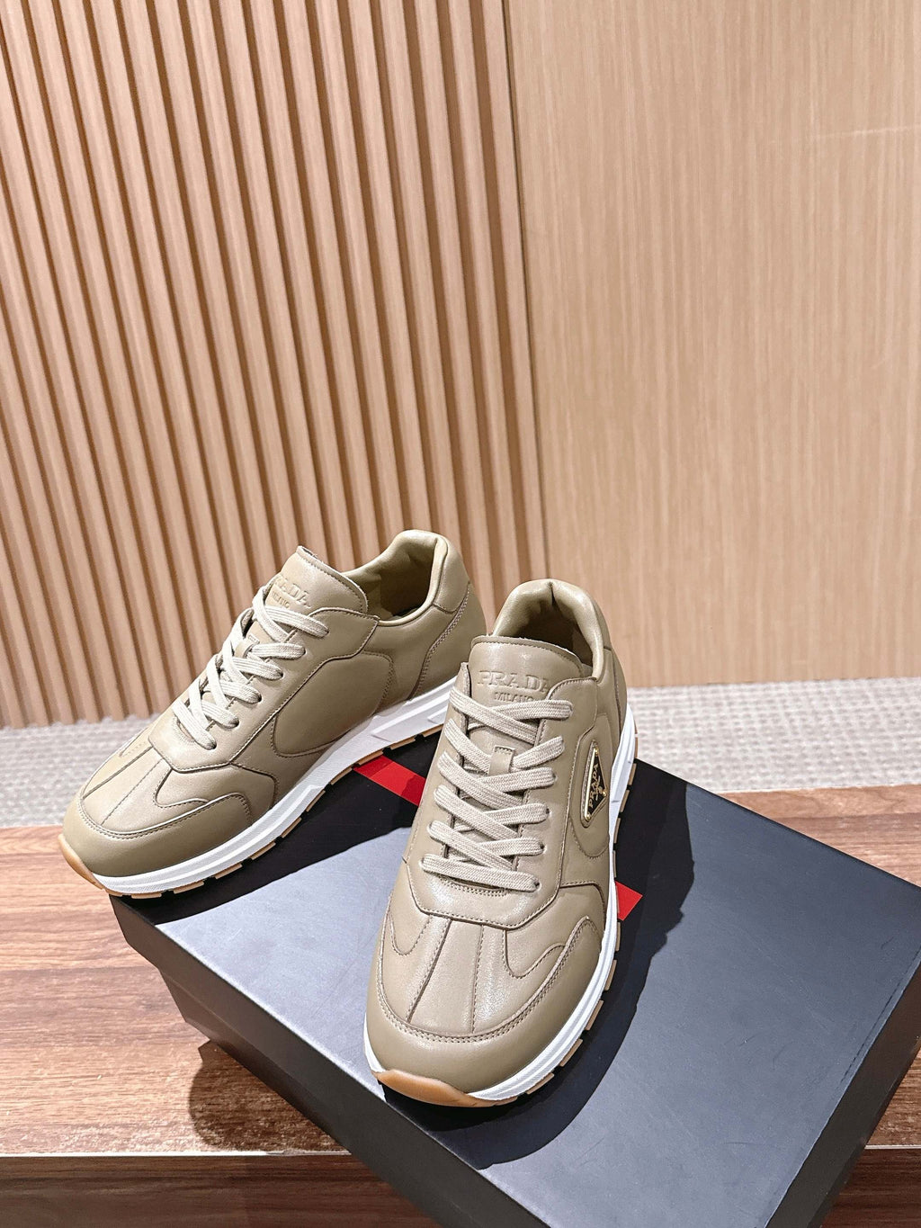 Prada unisex beige sneakers on display with lace-up closure and chunky sole