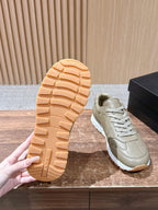 Prada unisex sneakers outsole and side view in light beige with white trim.