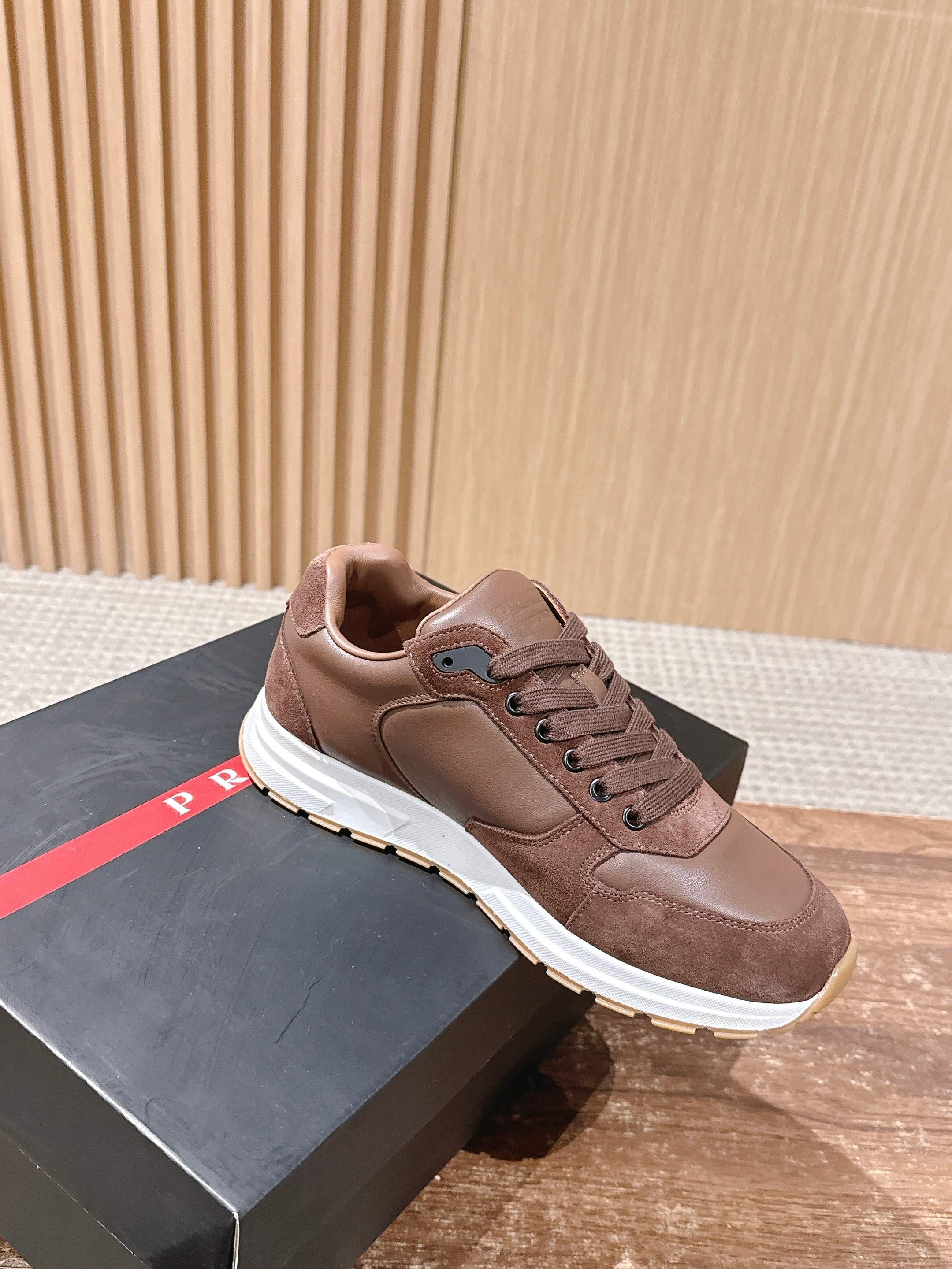Taupe lace-up unisex sneaker with logo patch detail and white sole.