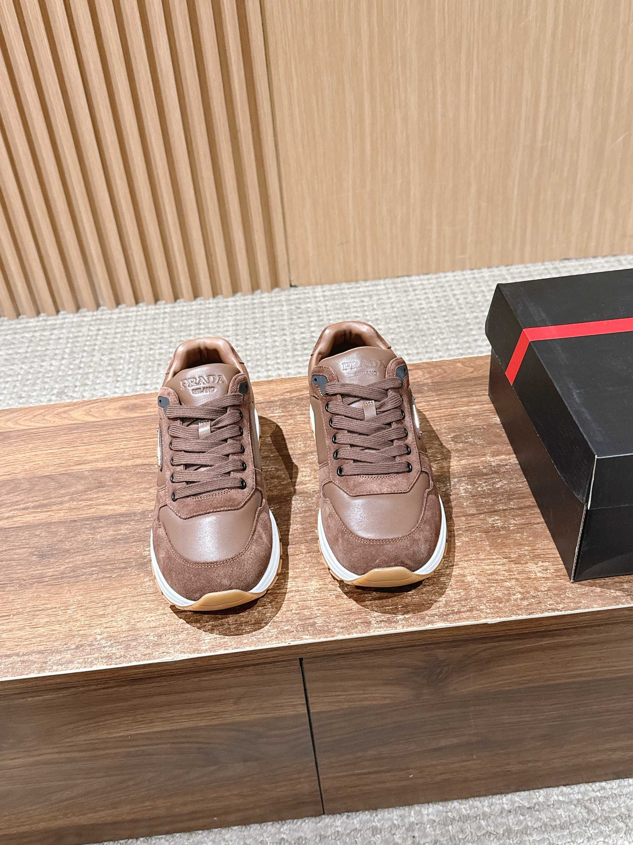 Taupe leather unisex sneakers with lace-up front and white rubber sole.