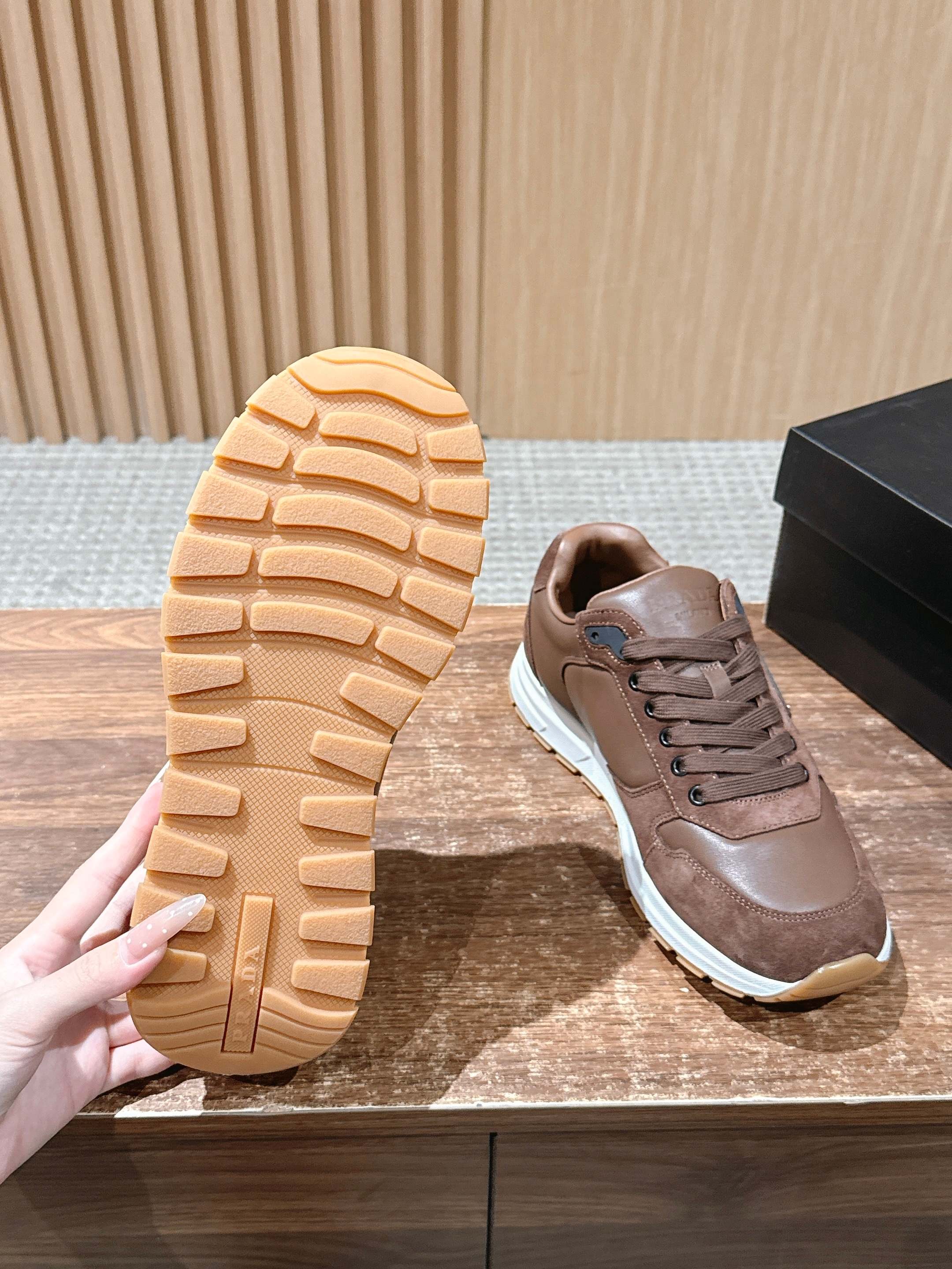Taupe sneaker outsole with textured tread and white midsole.