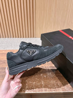 Dark suede-style unisex sneaker with Prada logo patch and lace-up front
