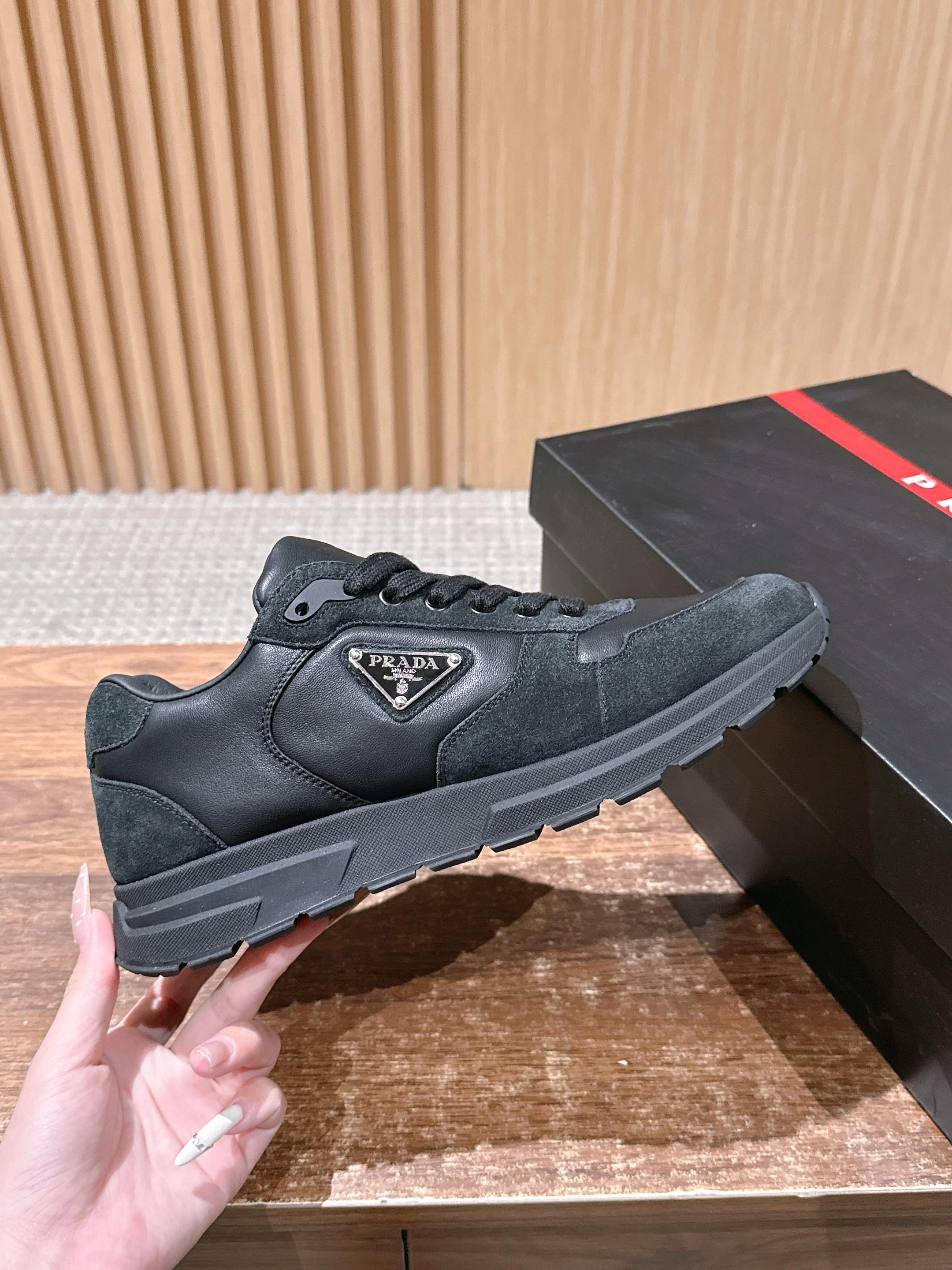 Dark suede-style unisex sneaker with Prada logo patch and lace-up front
