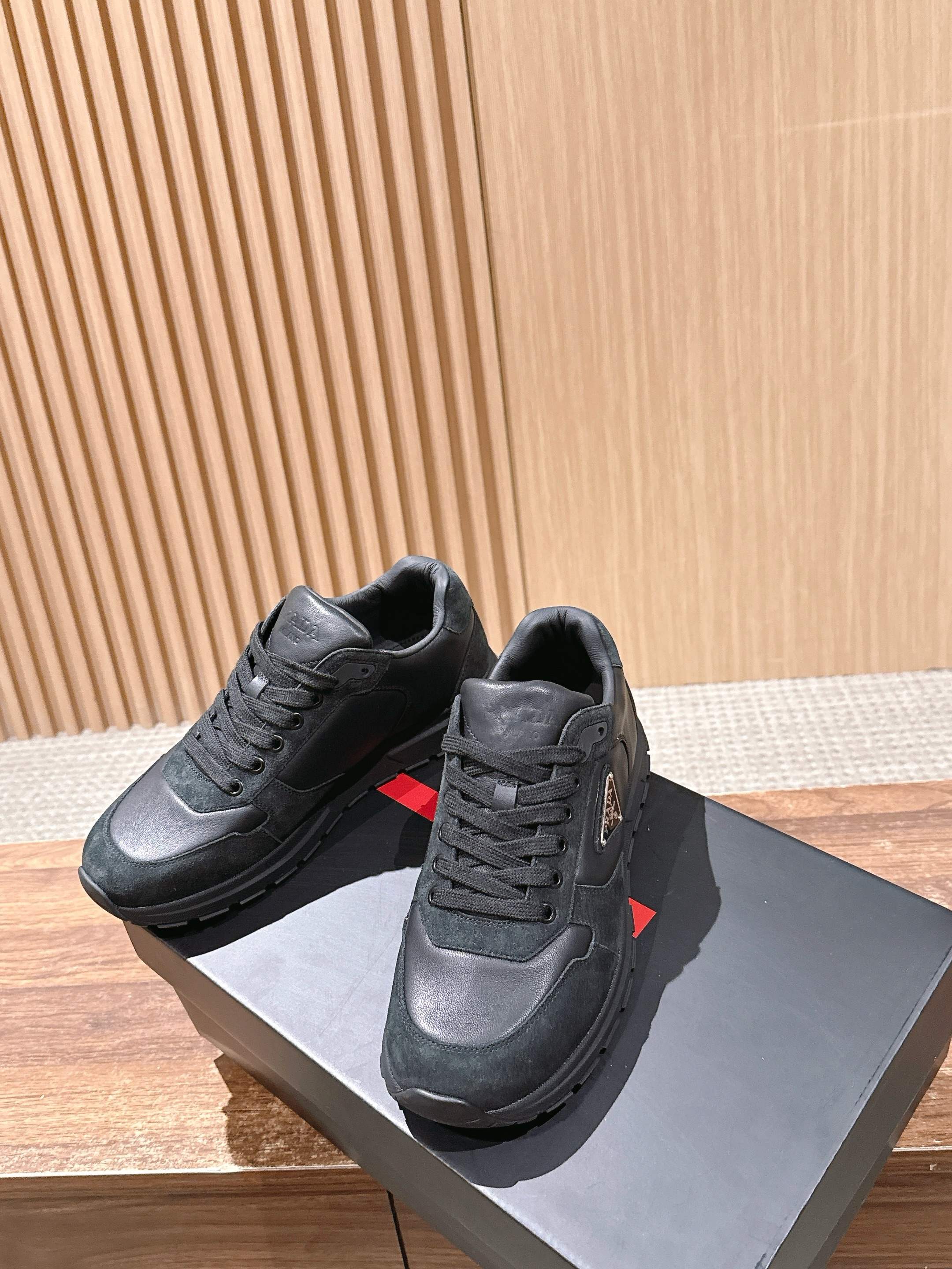 Dark unisex sneakers with lace-up closure and PRADA logo on the tongue