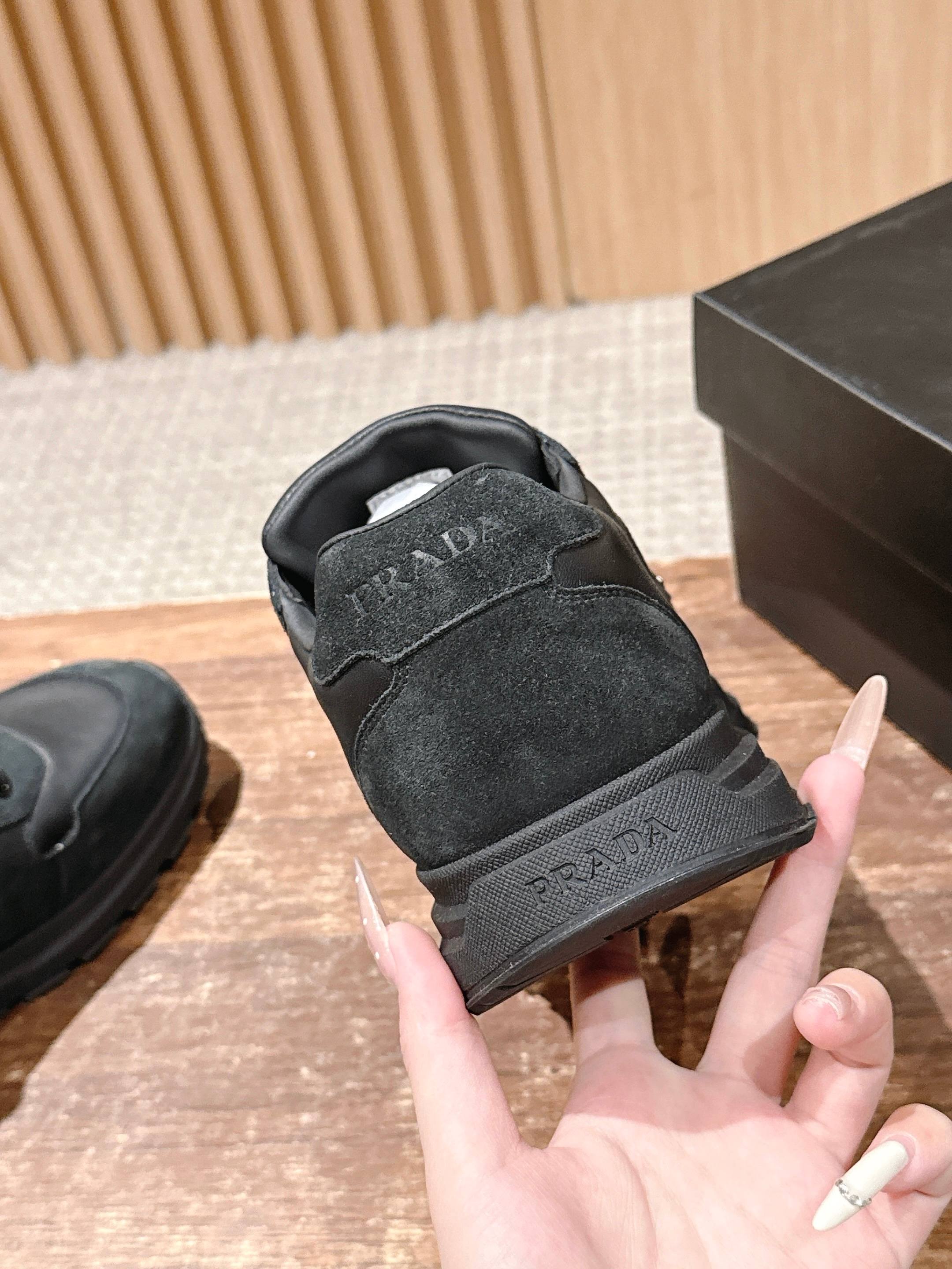 Dark unisex sneaker heel view with PRADA embossed detail and padded collar