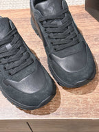 Dark leather unisex sneakers close-up, lace eyelets and rubber outsole
