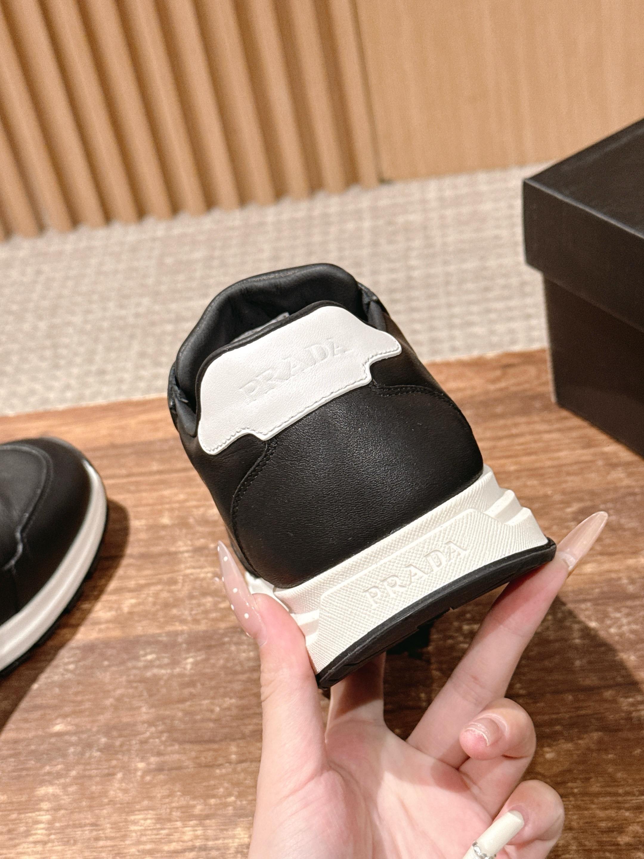 Prada unisex sneakers heel view, black leather with white sole edge
