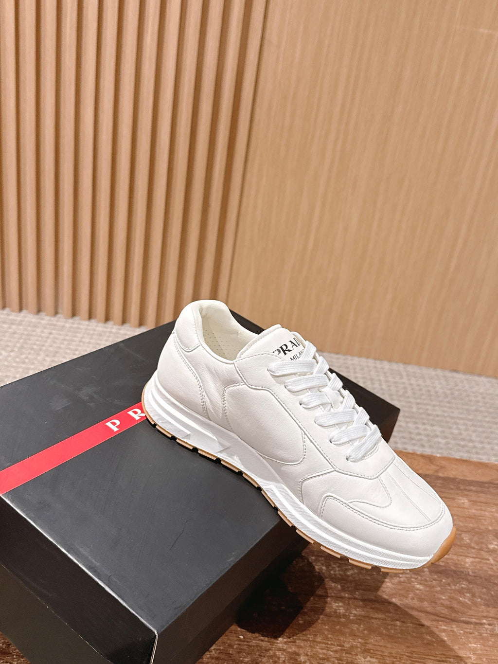 Prada white lace-up sneakers with cream laces and tan rubber sole