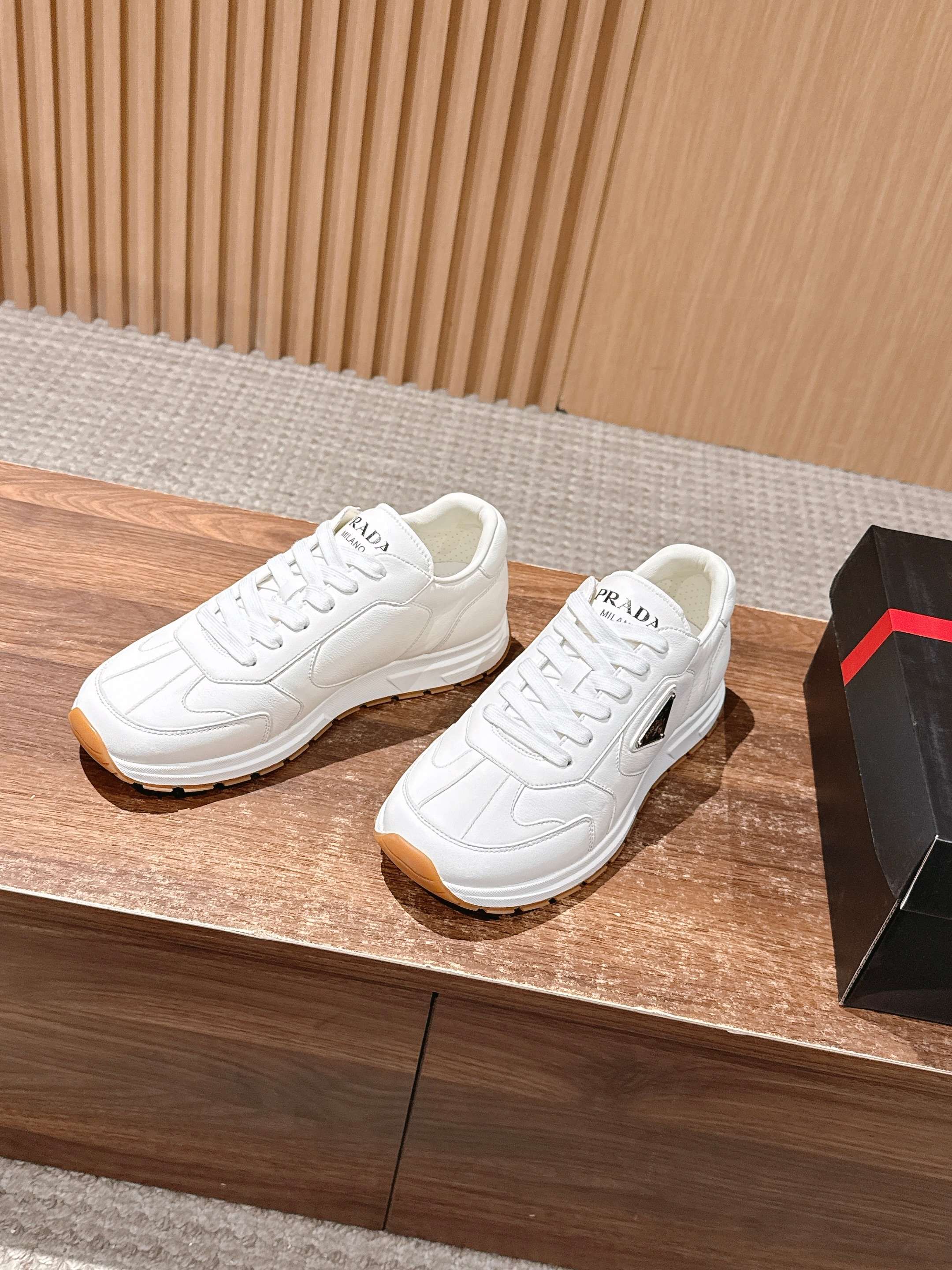 Prada white lace-up sneakers with tan outsole and textured side panels