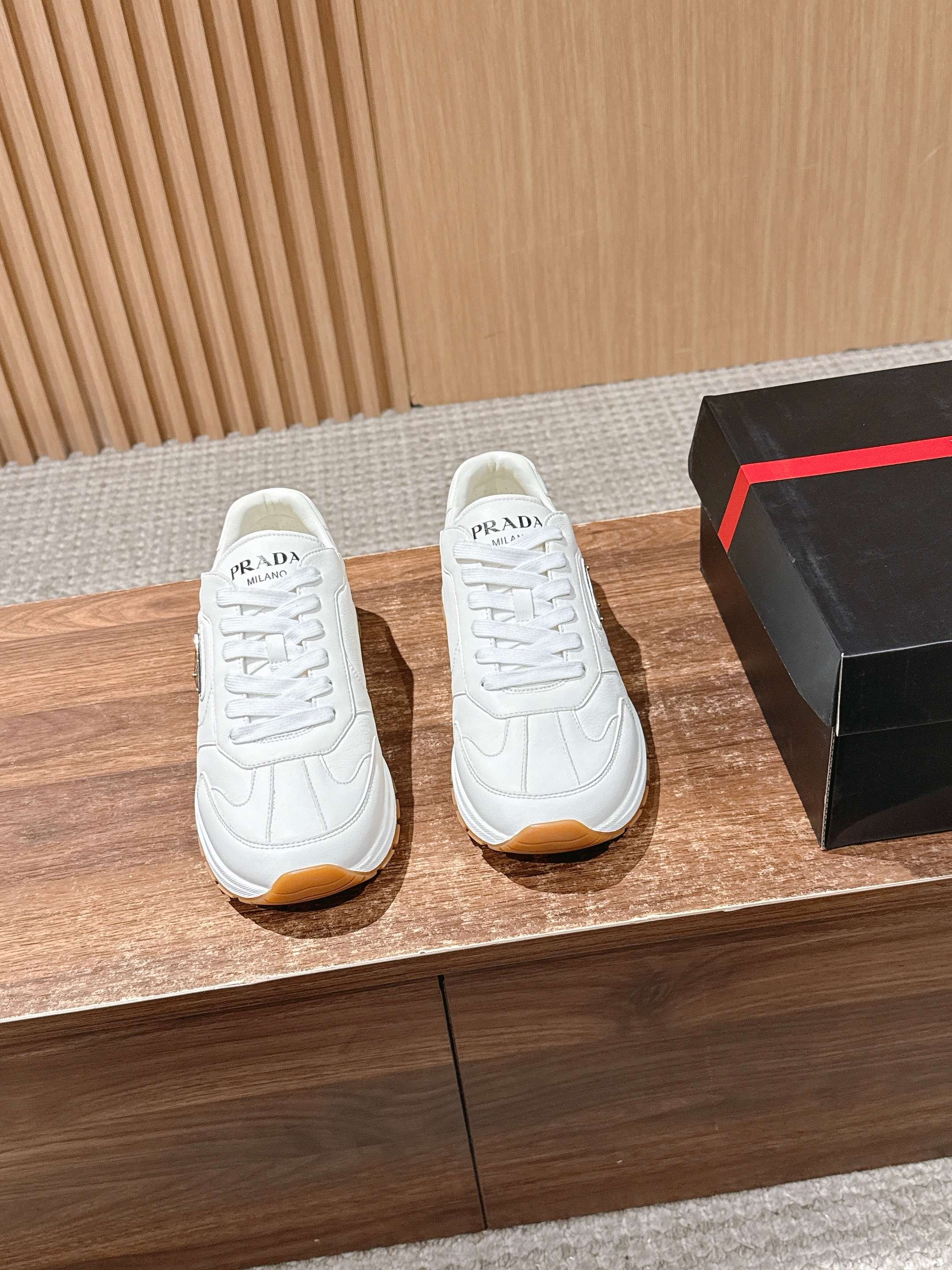 Prada white lace-up sneakers with textured side logo and tan rubber sole