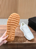 Prada white sneaker outsole view with tan rubber tread pattern