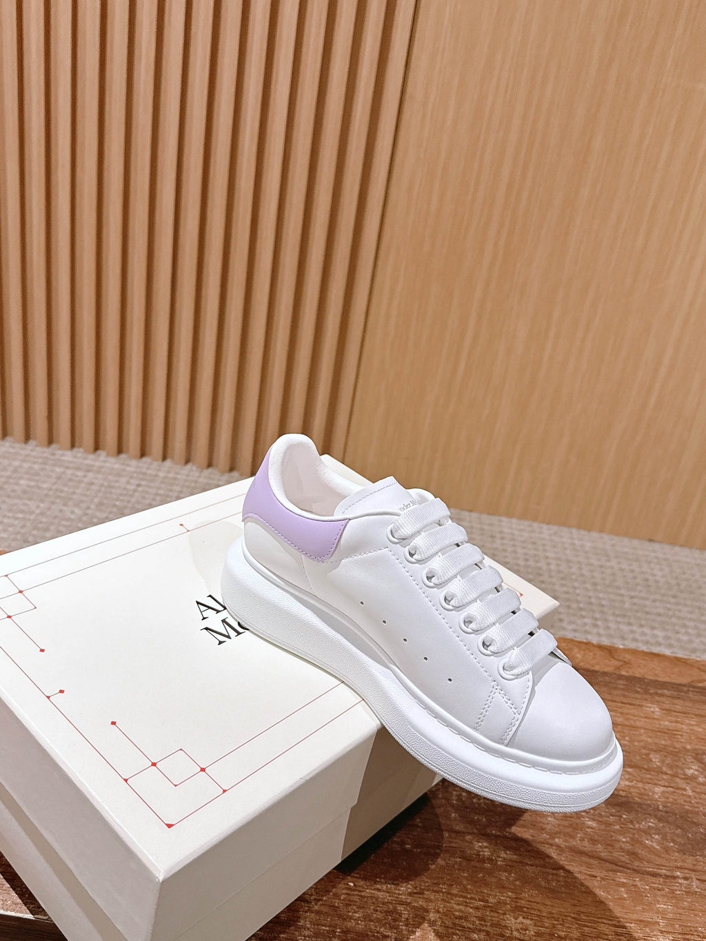 White leather sneakers with lavender collar panel, lace-up front on box