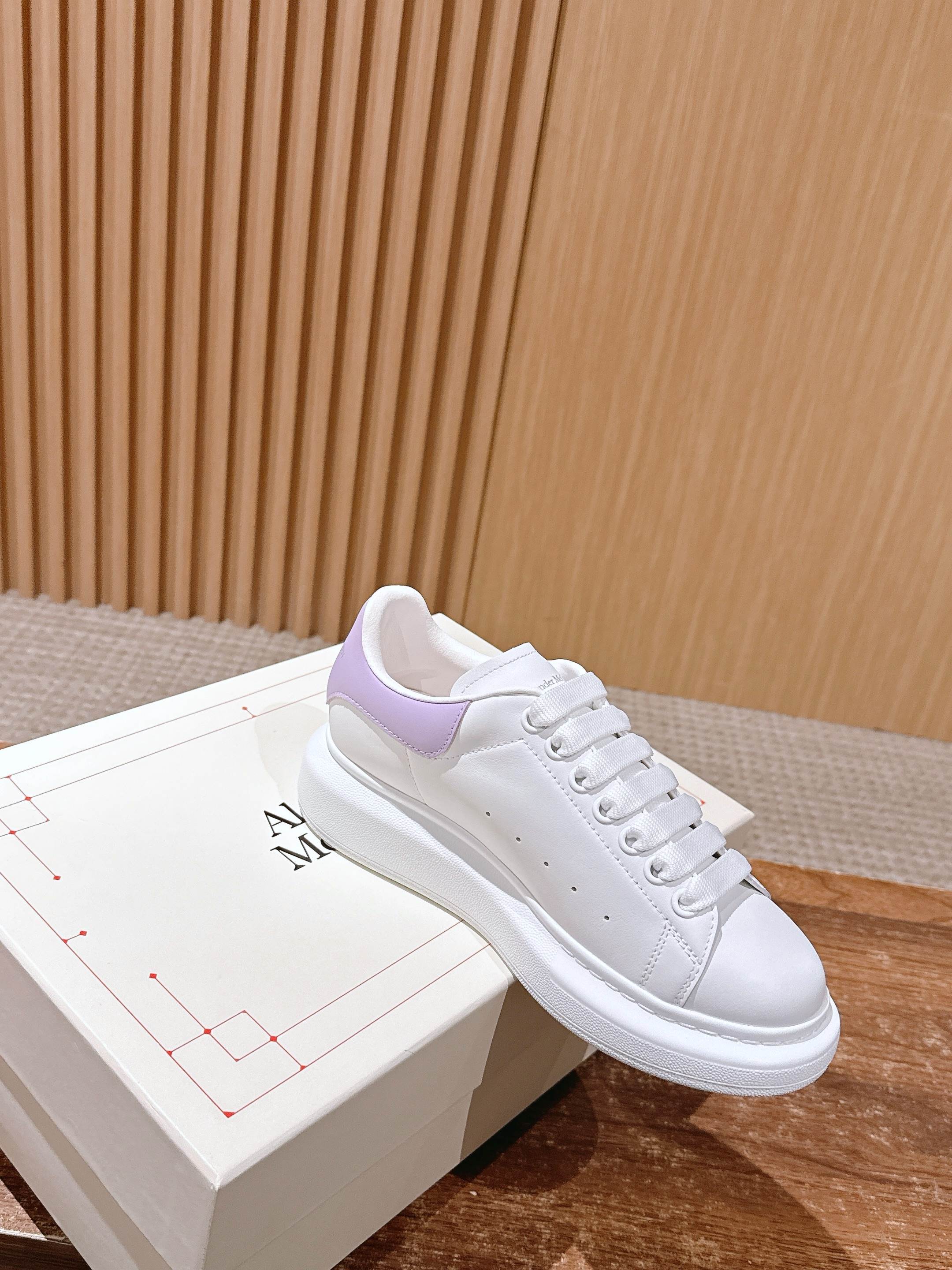 White leather sneakers with lavender collar panel, lace-up front on box
