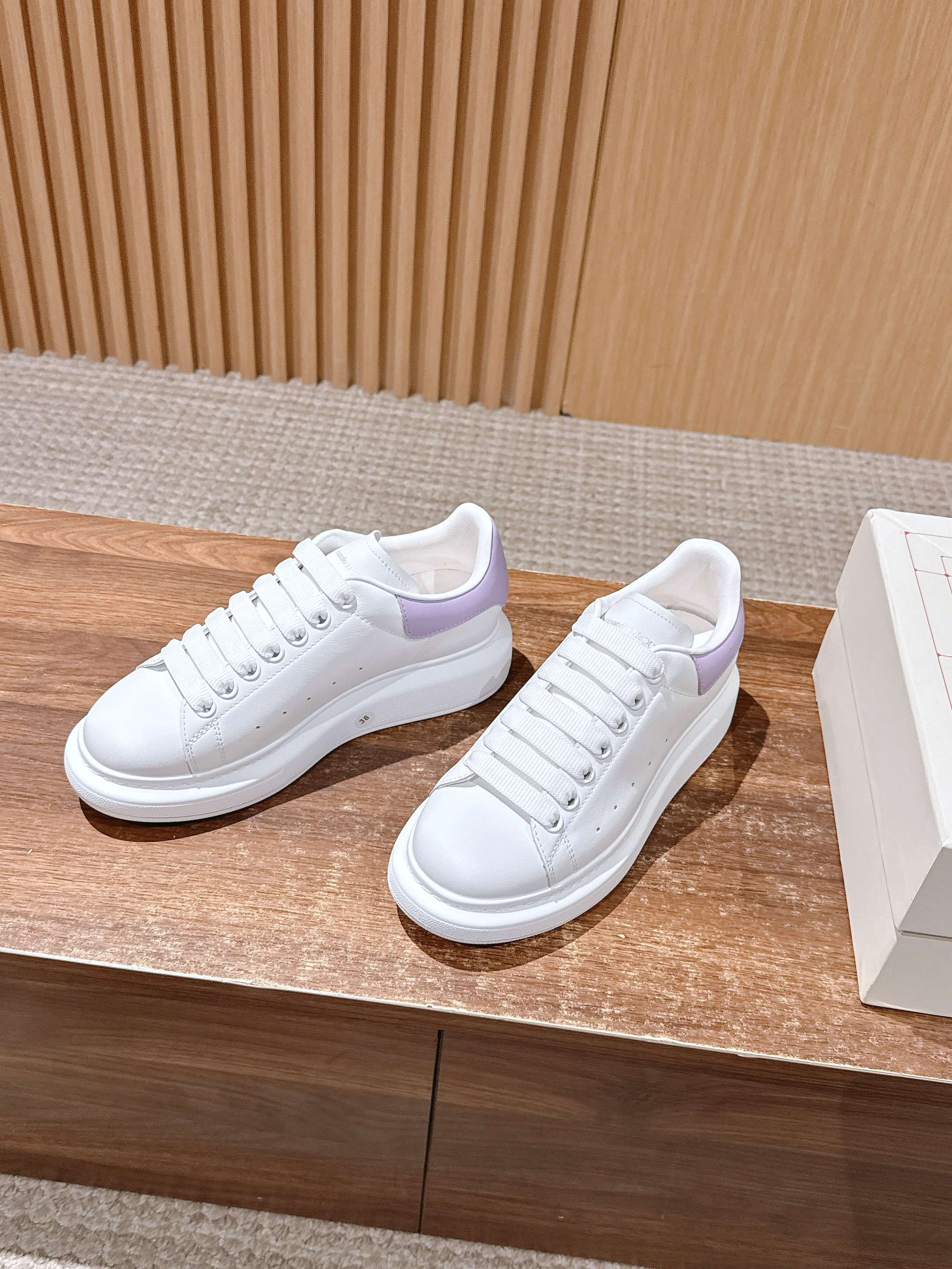White leather lace-up sneakers with lavender heel trim, shown side by side