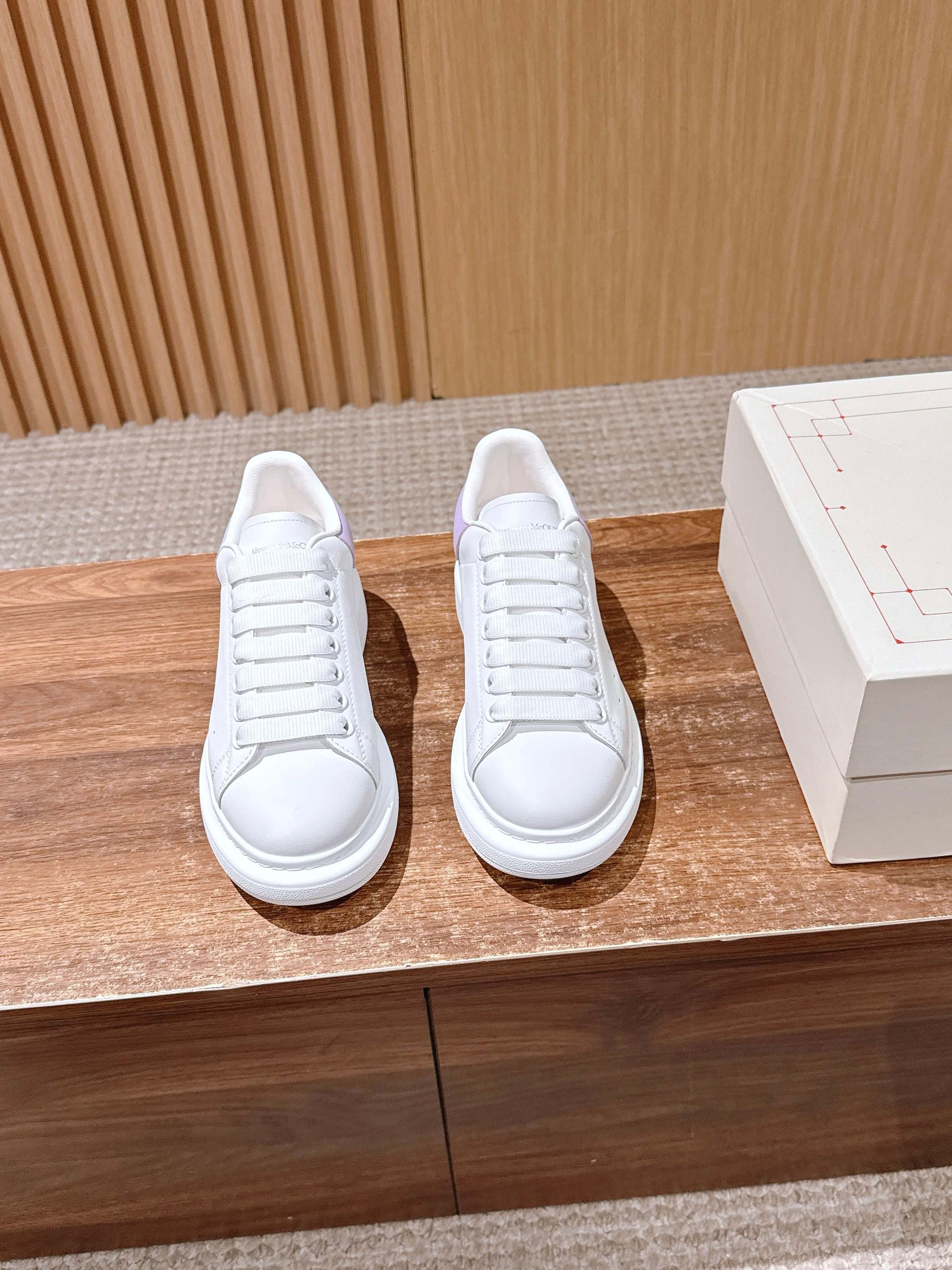 White leather lace-up sneakers with lavender side panels and white rubber soles