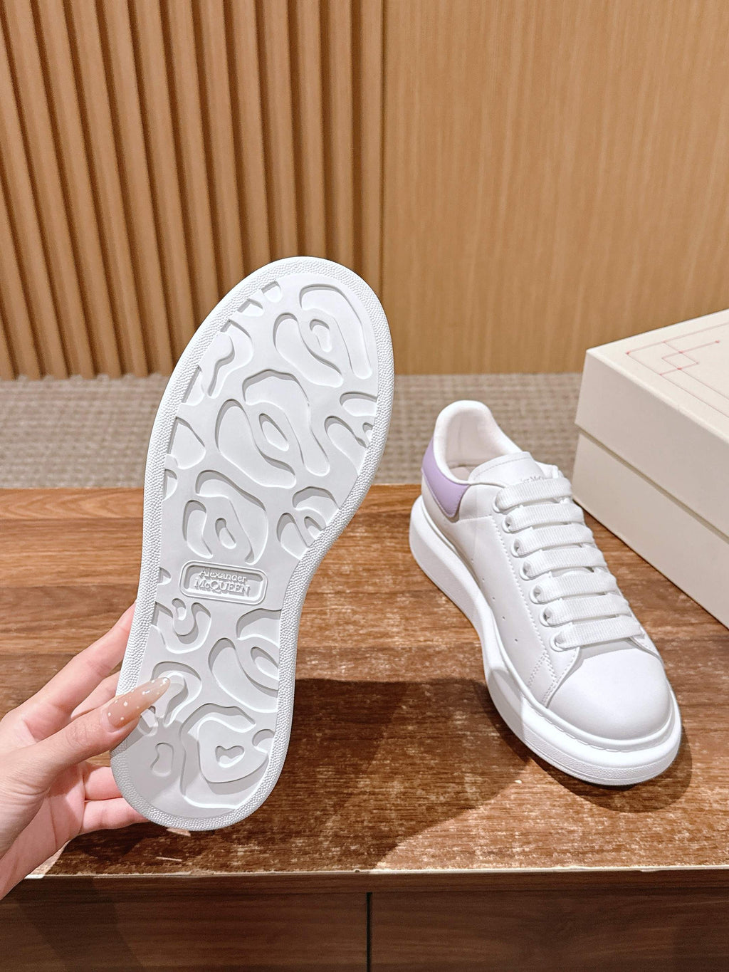 White leather sneakers outsole with tread and lavender heel accent, side view