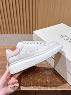 White leather sneakers with pink accent heel lining and lace-up design