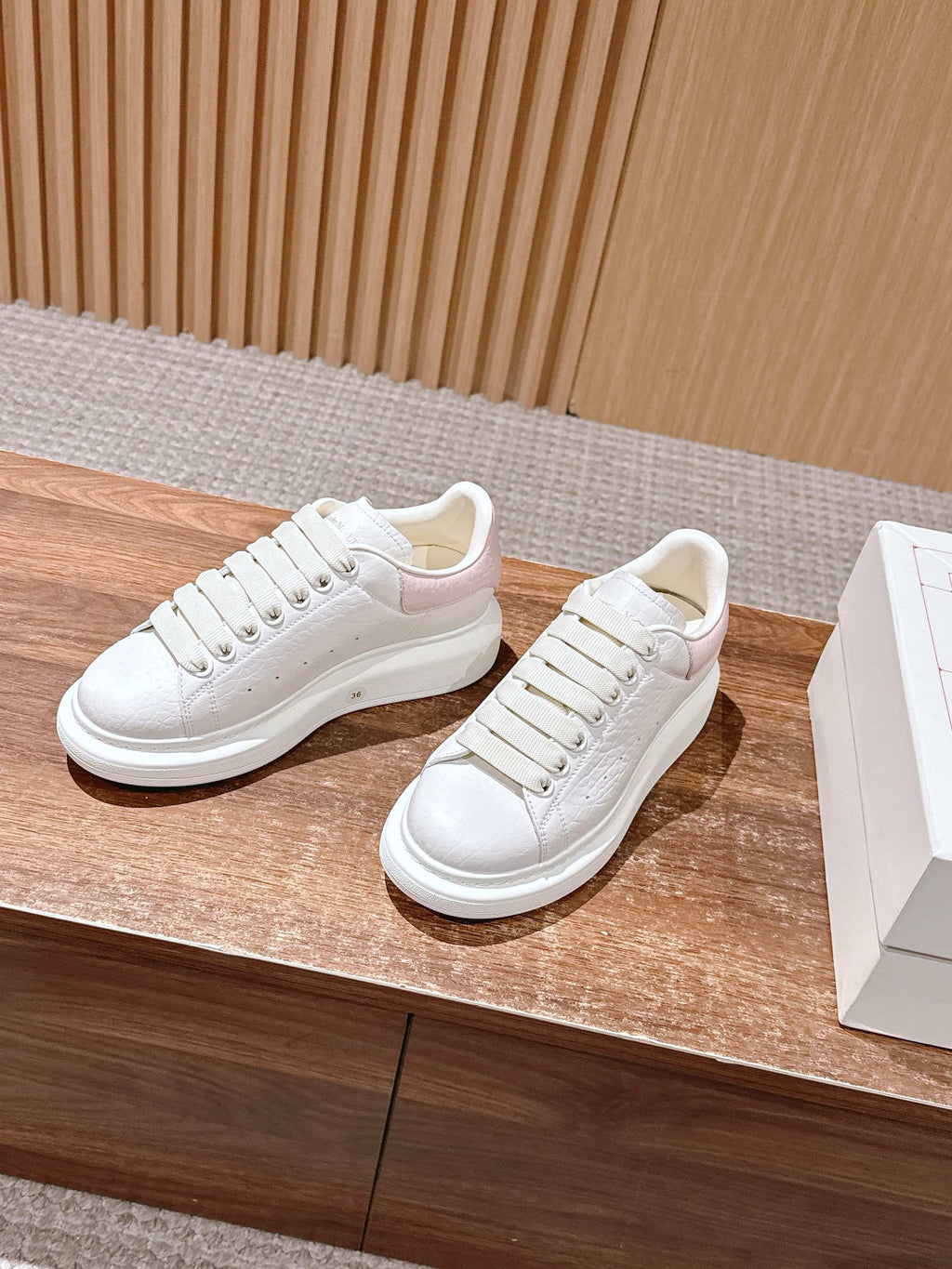 White leather low-top sneakers with lace-up front and clean cupsole profile