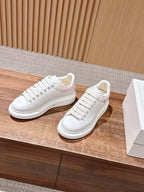 White leather low-top sneakers with lace-up front and clean cupsole profile